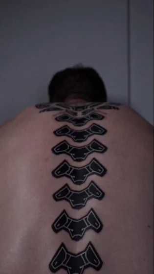 Biomechanical and Blackwork spine tattoo design for men on back