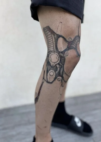 Biomechanical mechanical parts tattoo design for men on knee and leg