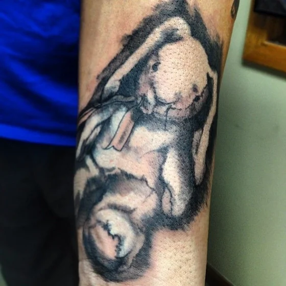 Black And Grey Sketch Plush Bunny tattoo design for men on forearm