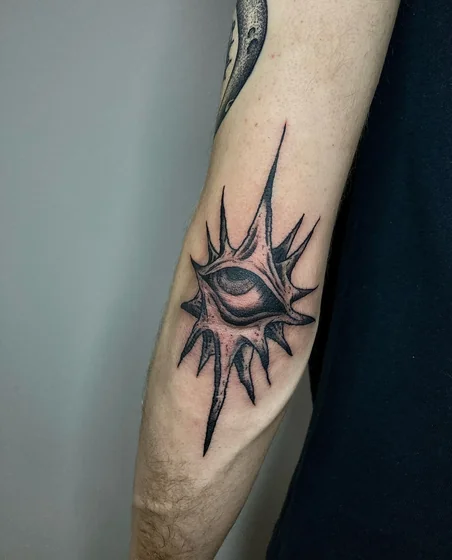 Black and Grey Surreal Spiky Eye tattoo design for men on elbow
