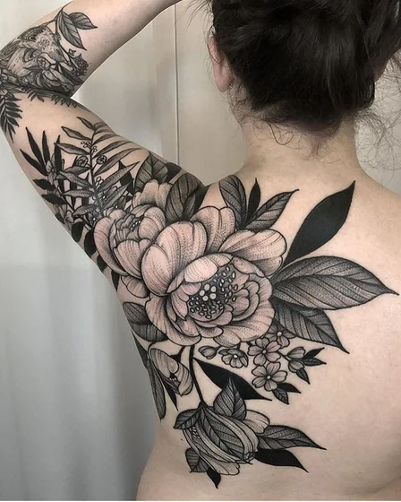 Black and grey blackwork floral tattoo design for women on back and upper arm