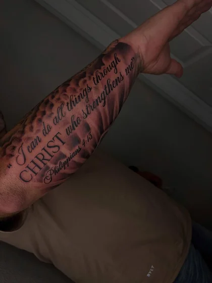 Black and grey script Christian quote tattoo for men on forearm