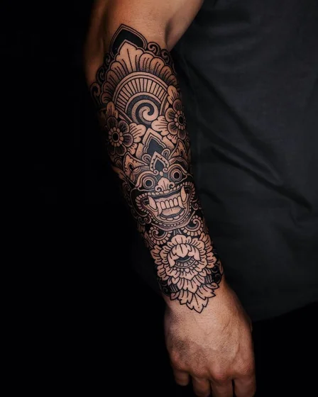 Blackwork Traditional Mask and Floral tattoo design for men on forearm.