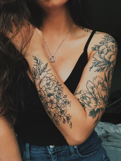 Blackwork floral & Roman numeral tattoo design for women on arm