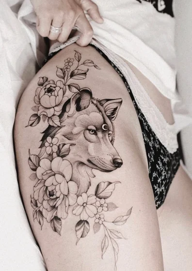 Blackwork wolf and floral tattoo design for women on thigh