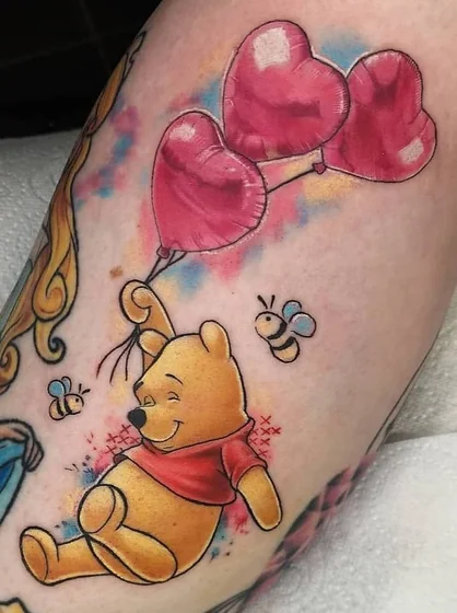 Disney Winnie Pooh with heart balloons and bees watercolor tattoo idea for women on arm.