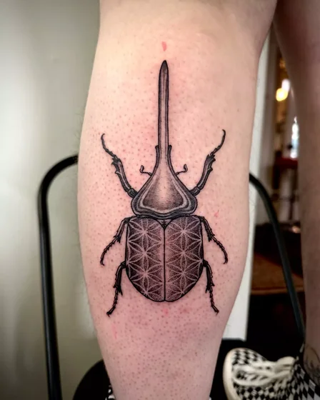 Dotwork fine line beetle tattoo design for men on calf