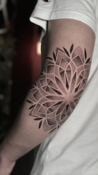 Dotwork geometric mandala tattoo design for men on elbow and upper arm
