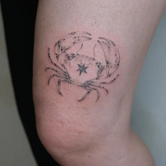 Fine Line Black And Grey Crab and Star tattoo idea for women on thigh.