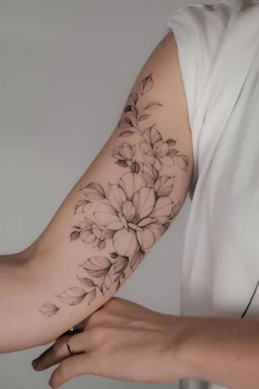 Fine Line Black And Grey floral tattoo idea for women on upper arm