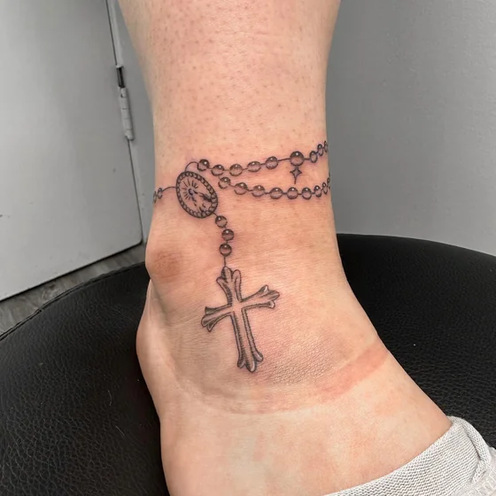 Fine Line Black And Grey rosary tattoo design for women on ankle