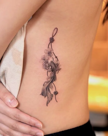 Fine Line Koi Fish and Floral tattoo idea for women on rib