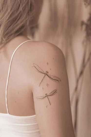 Fine Line Minimalist Dragonfly tattoo for women on shoulder and upper arm