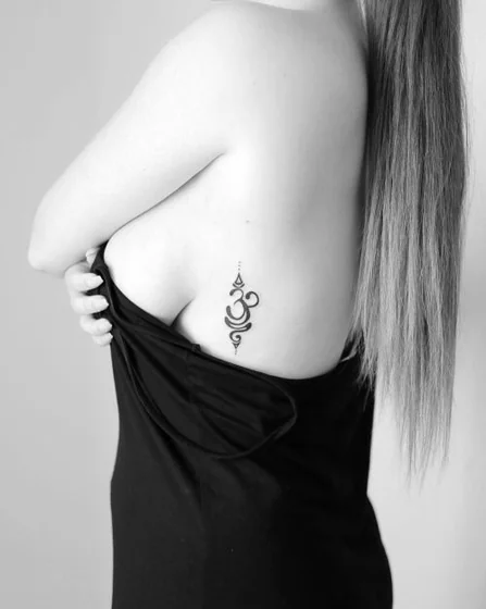 Fine Line Minimalist Om Symbol tattoo design for women on rib