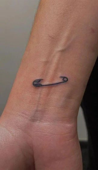 Fine Line Minimalist Safety Pin tattoo idea for women on Wrist