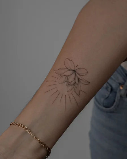 Fine Line Minimalist flower and sun tattoo design for women on forearm