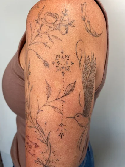Fine Line Sketch floral rose hummingbird dragonfly starburst tattoo idea for women on upper arm
