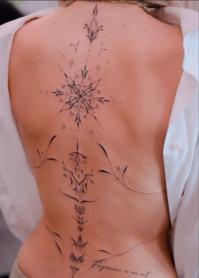Fine Line and Dotwork star, flower, and floral tattoo design for women on back