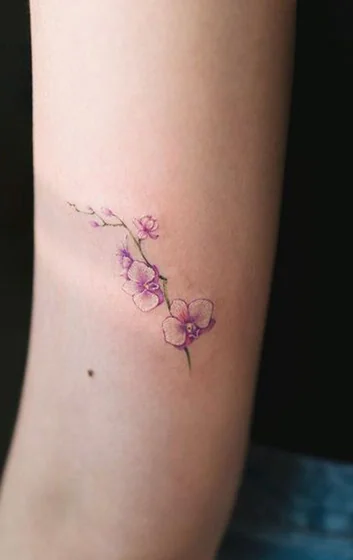 Fine Line and Minimalist floral tattoo design for women on upper arm