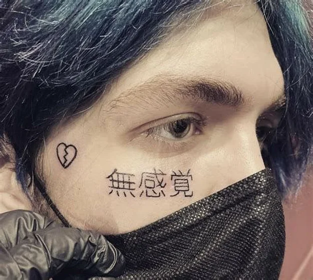 Fine Line broken heart and Japanese script face tattoo for men