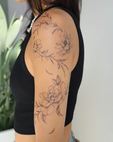 Fine Line floral tattoo design for women on upper arm and shoulder