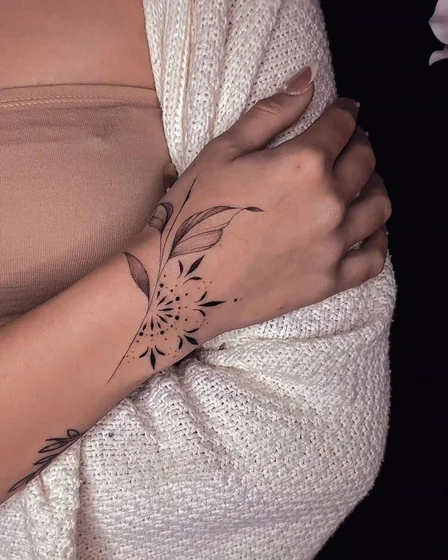Fine Line floral tattoo idea for women on hand and wrist