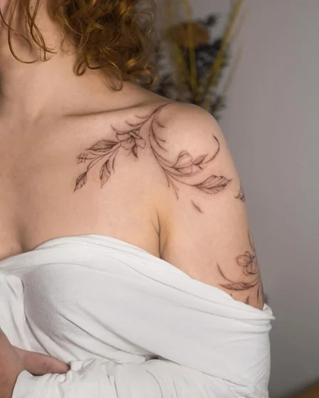 Fine Line floral vine tattoo design for women on shoulder and upper arm
