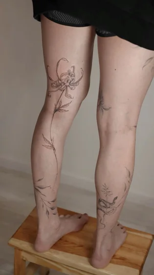 Fine Line flower and snake tattoo design for women on thigh and calf