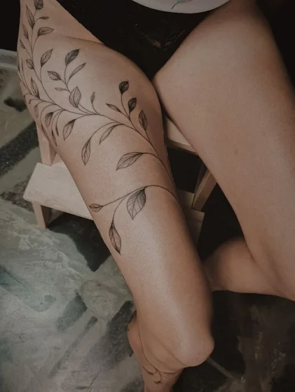 Fine Line linework floral vine tattoo design for women on thigh