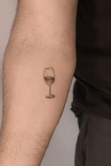 Fine Line minimalist Wine Glass tattoo idea for men on upper arm