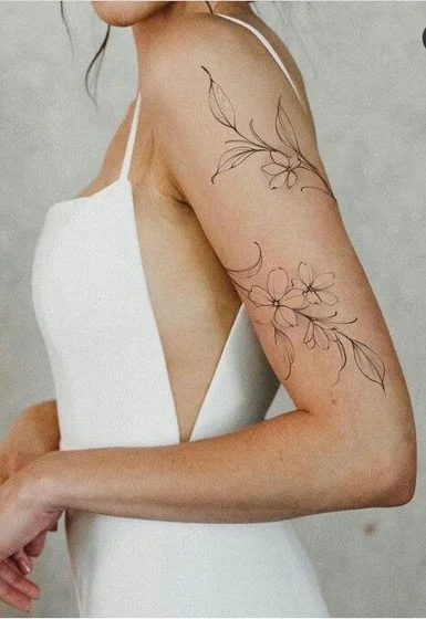 Fine Line minimalist floral tattoo design for women on upper arm