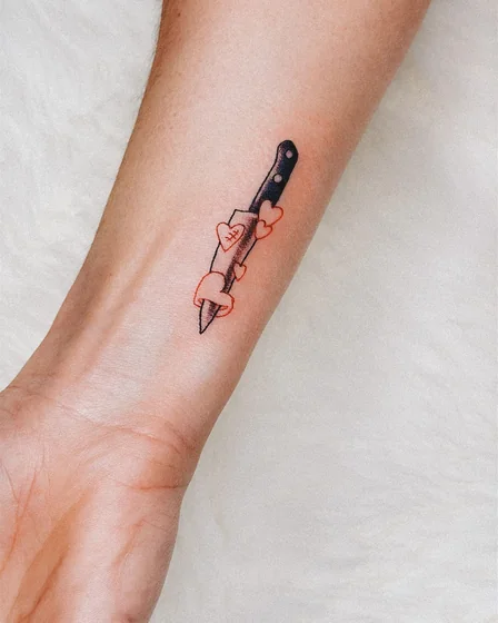 Fine Line minimalist knife with hearts tattoo design for women on forearm