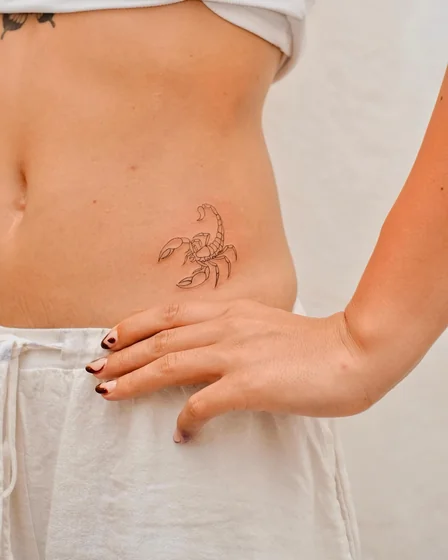 Fine Line minimalist scorpion tattoo design for women on hip.