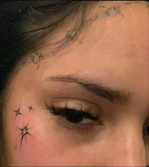 Fine Line star and barbed wire tattoo design for women on face