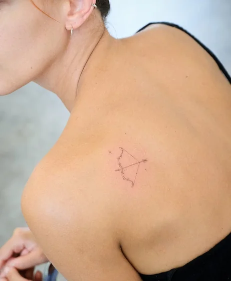Fine line Sagittarius bow and arrow tattoo for women on shoulder