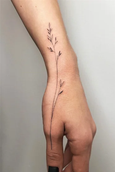 Fine line floral tattoo design for women on wrist and hand