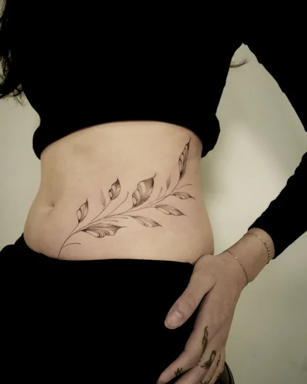 Fine line floral vine sketch tattoo idea for women on rib