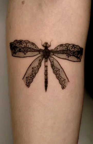 Fine line lace dragonfly tattoo design for women on upper arm.
