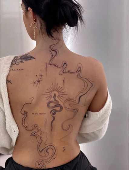Fine line patchwork snake, sun, star tattoo idea for women on back