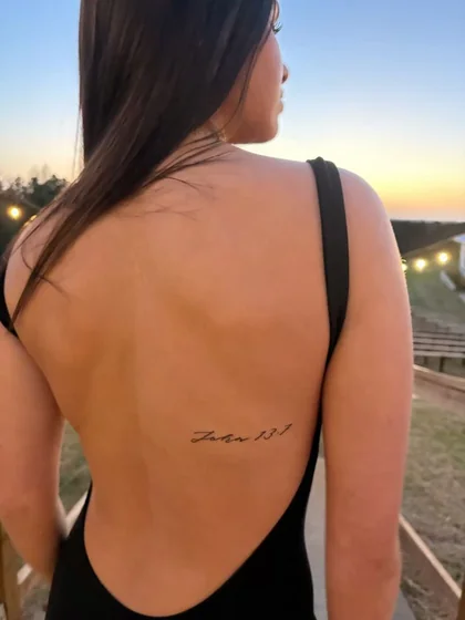 Fine line script Bible verse tattoo for women on back and rib