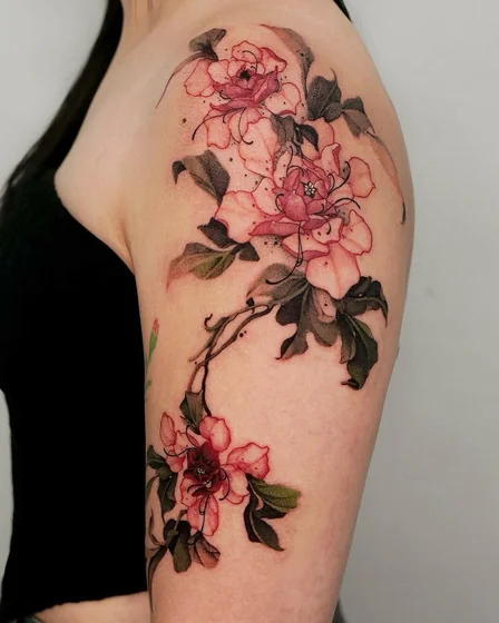 Fine line watercolor floral tattoo design for women on upper arm.