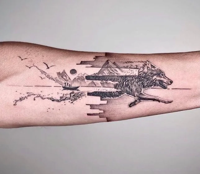 Fragmented wolf and mountain tattoo idea for men on forearm.
