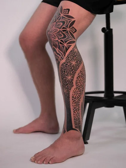 Geometric Blackwork tattoo design for men on leg and knee