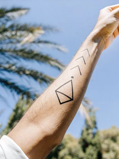 Geometric arrow and abstract shape tattoo for men on forearm