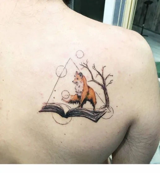 Geometric watercolor fox and book tattoo for men on shoulder.