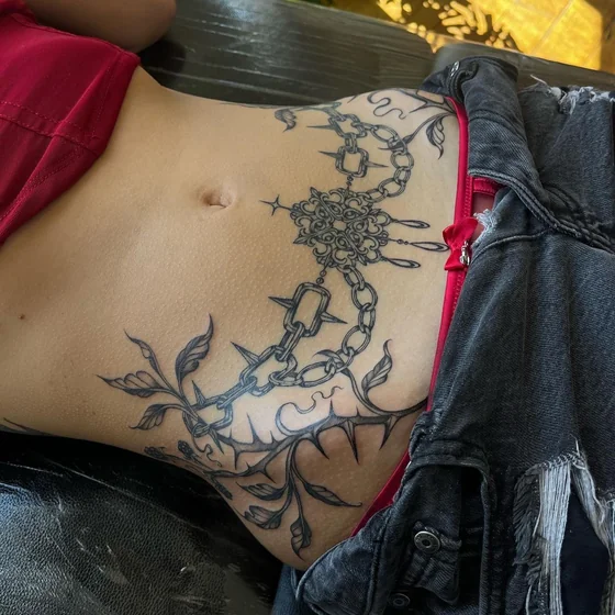 Gothic ornamental chain and vine tattoo idea for ladies on hip