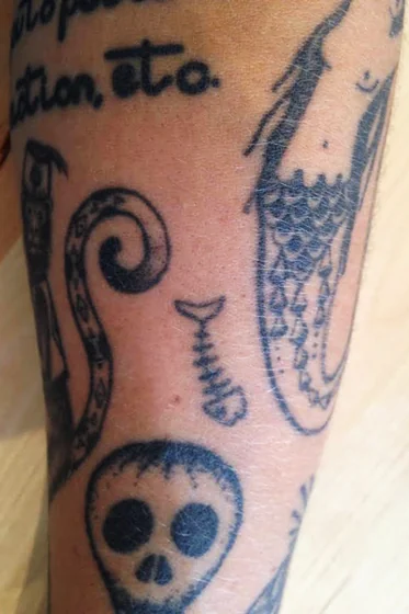 Ignorant patchwork forearm tattoo idea for men: skull, mermaid