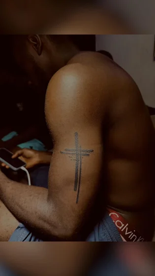 Ignorant sketch cross tattoo idea for men on bicep