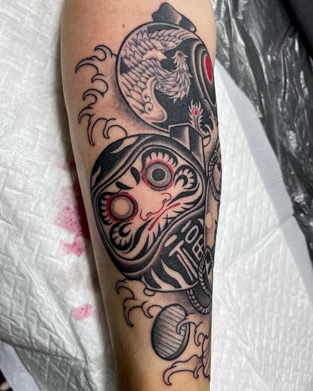 Japanese Daruma Doll, Phoenix, Ocean tattoo idea for men and women on forearm.