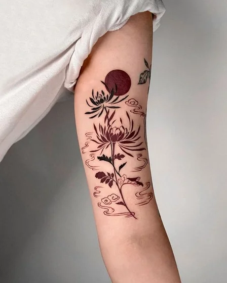 Japanese minimalist floral and cloud tattoo design for women on upper arm